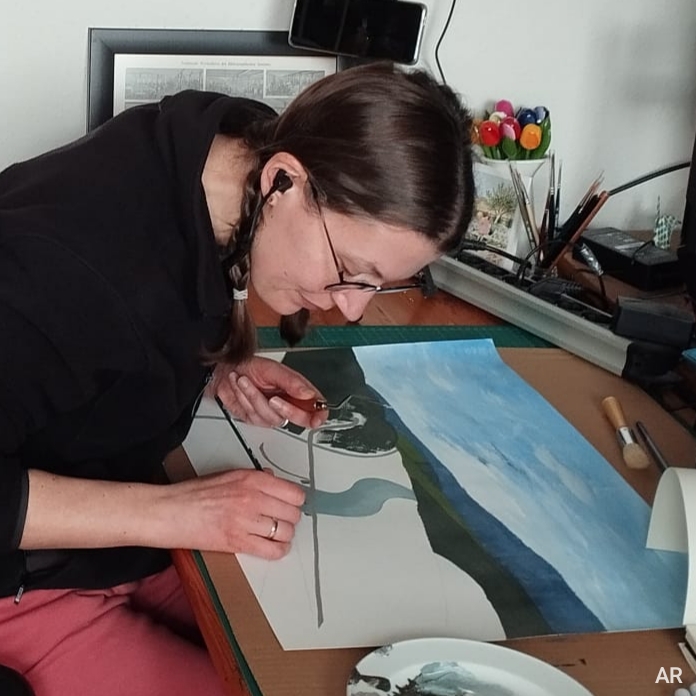 Annika sitting at her studio desk drawing and listening to music
