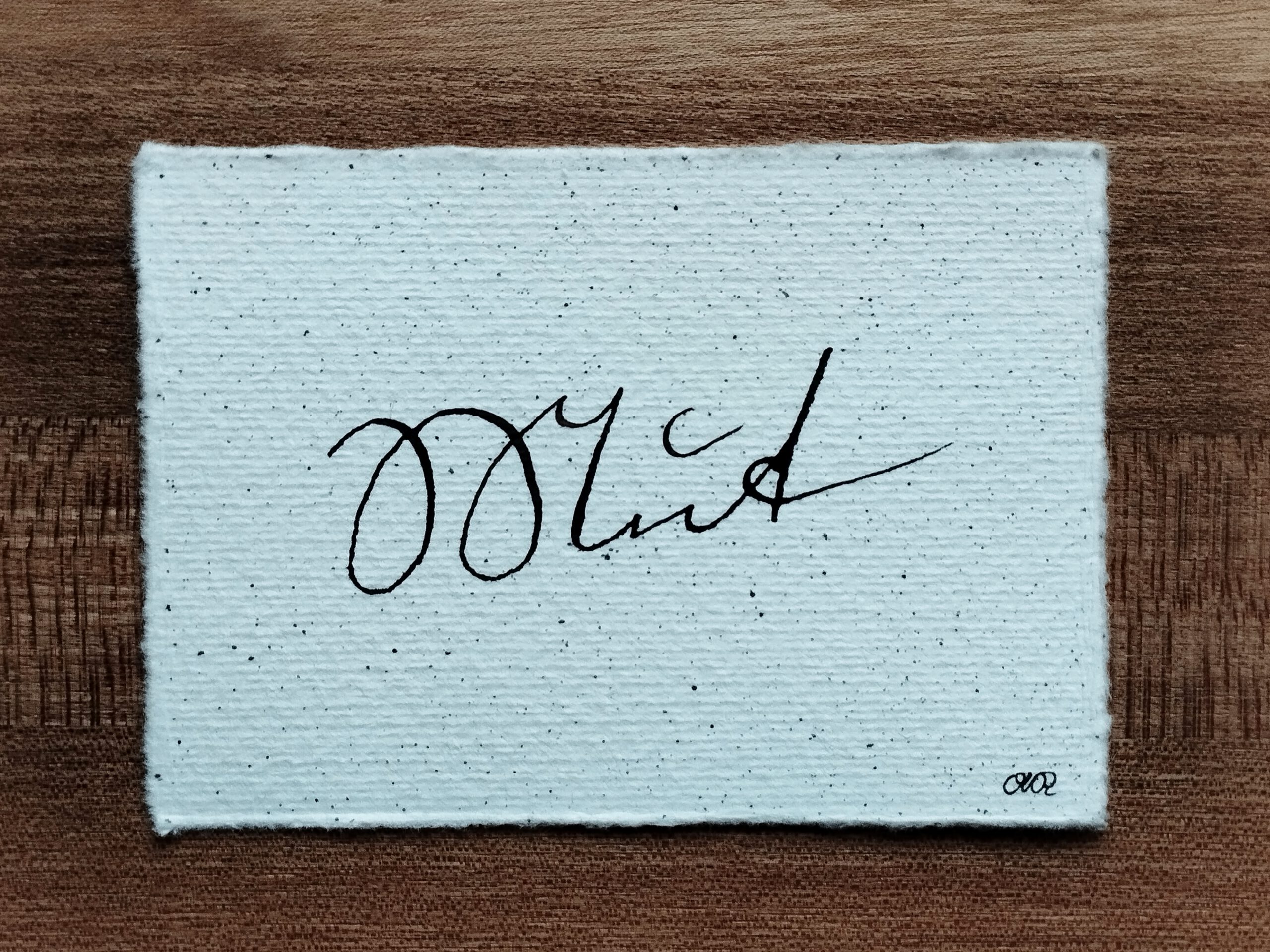 Schriftzug "Mein Weg" in Kurrentschrift in umbrafarbener Tusche auf Büttenpapier mit Tintensprenkeln